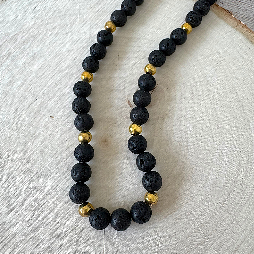 Black Lava and Gold Round Beaded Mens Necklace On Wood
