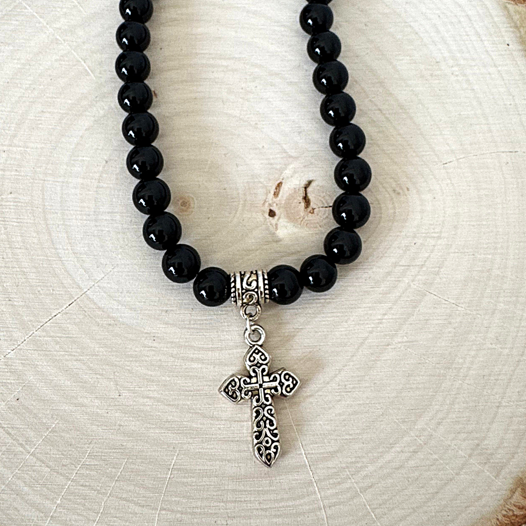 Black Onyx and Silver Detailed Cross Mens Beaded Necklace On Light Wood Table