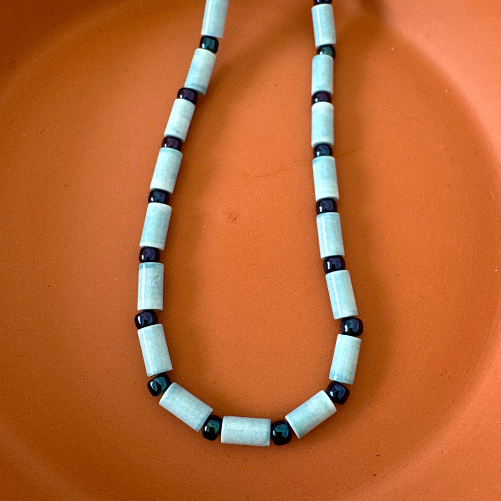 Denim Blue Agate Tube and Metallic Blue Toho Beaded Mens Necklace On A Dish.