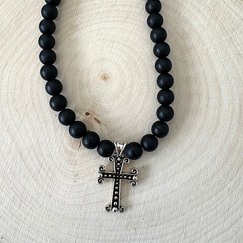 Matte Black Onyx and Ornate Silver Cross Mens Beaded Necklace On Wood