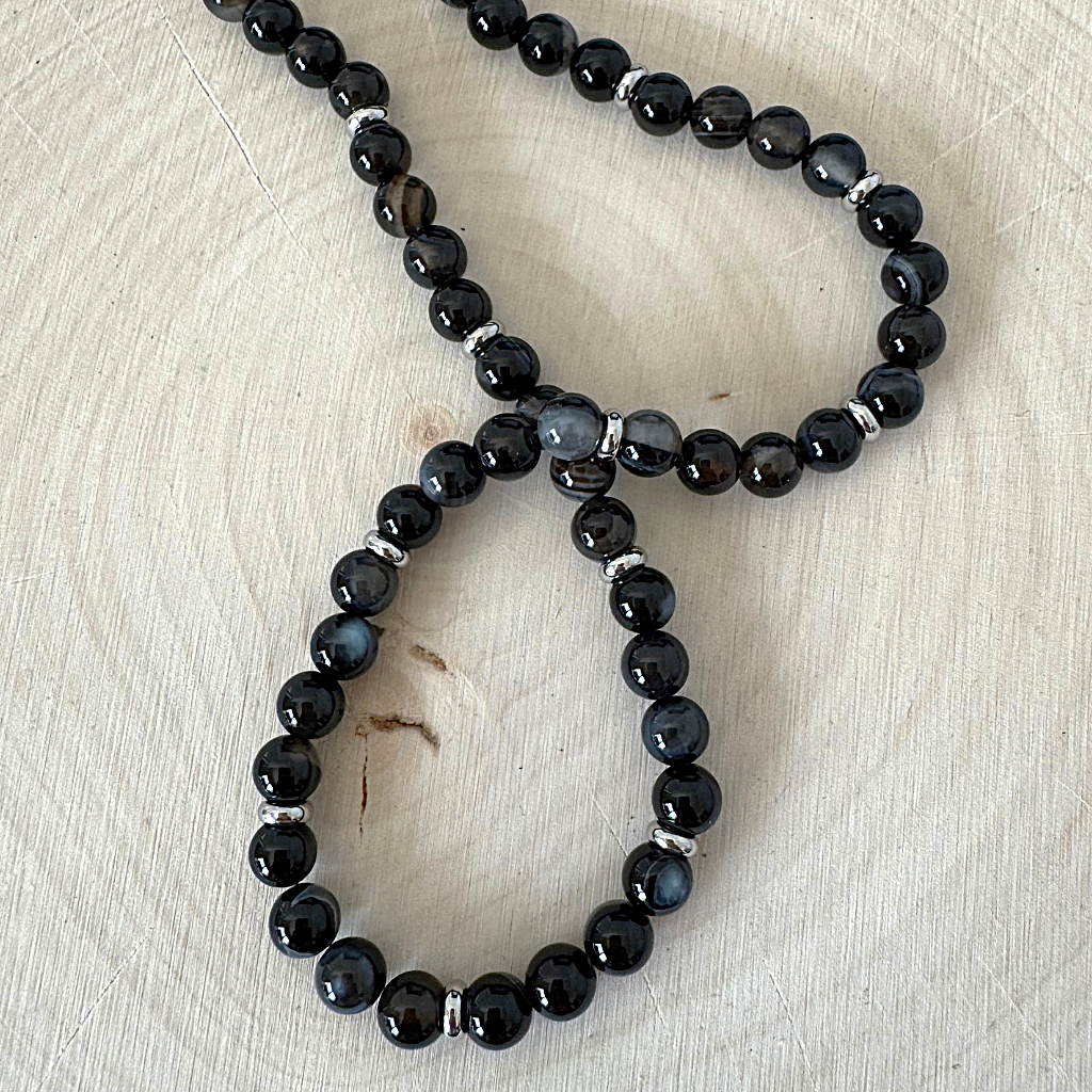Mens 6mm Black Sardonyx and Silver Spacer Beaded Necklace On Light Wood Table