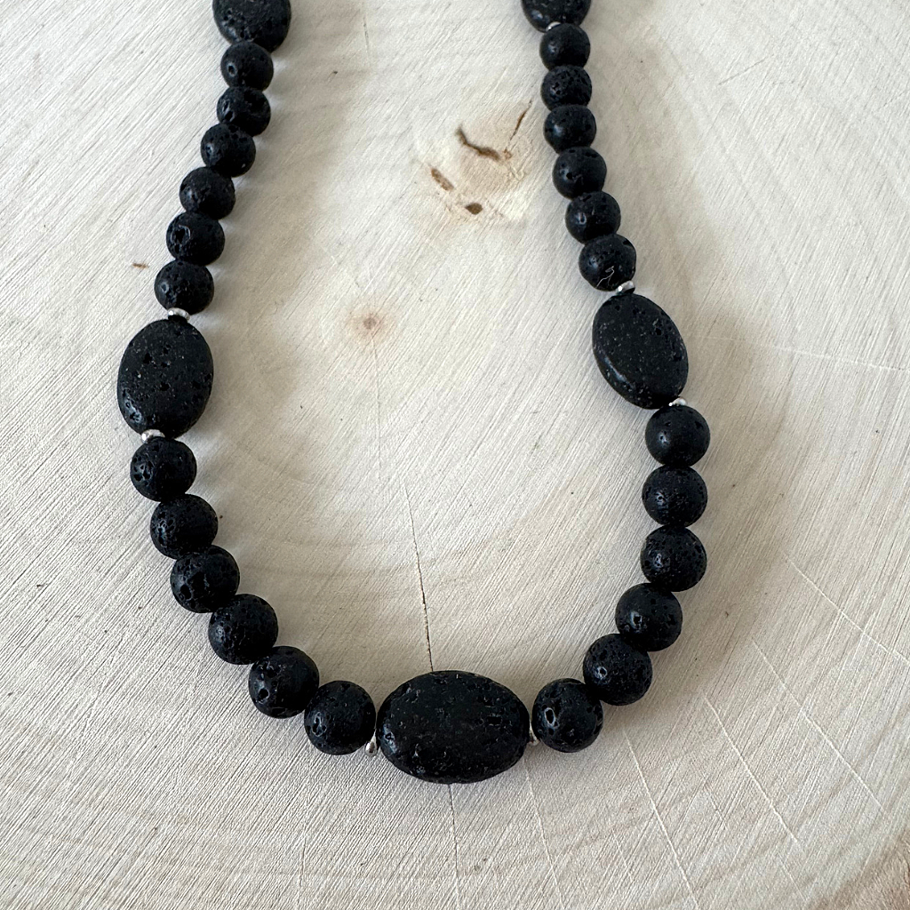Mens Black Lava 6mm and Oval Beaded Necklace on a light wooden surface
