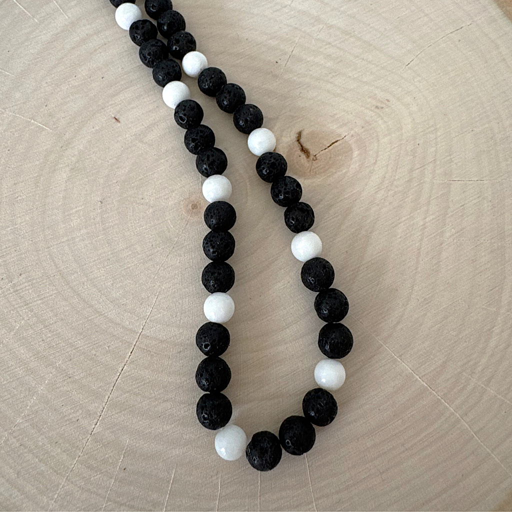 Mens Black Lava and White Shell Beaded Necklace On Wood