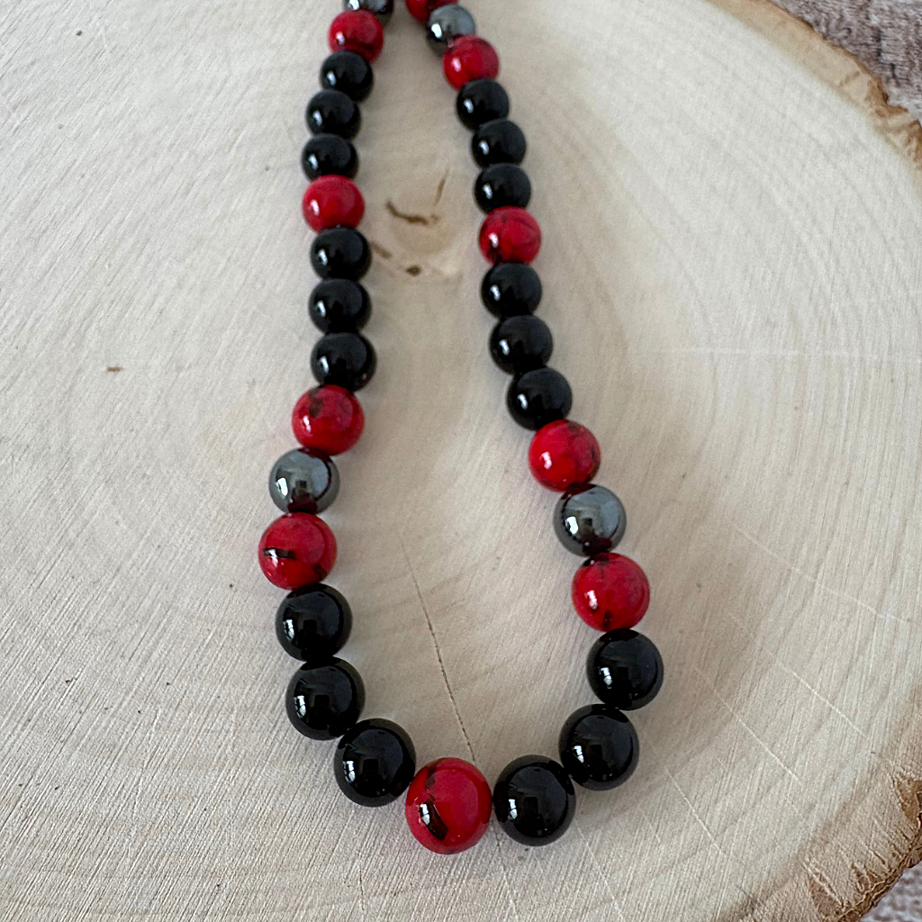 Mens Black Onyx and Red Mosaic Beaded Necklace on a wooden surface
