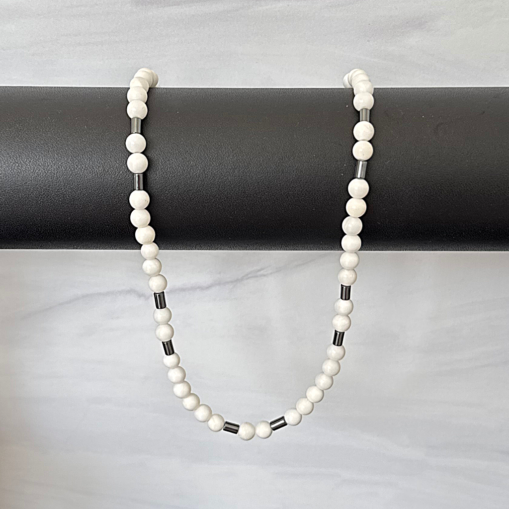 Mens White Shell and Black Hematite Tube Beaded Necklace Draped Over Bar