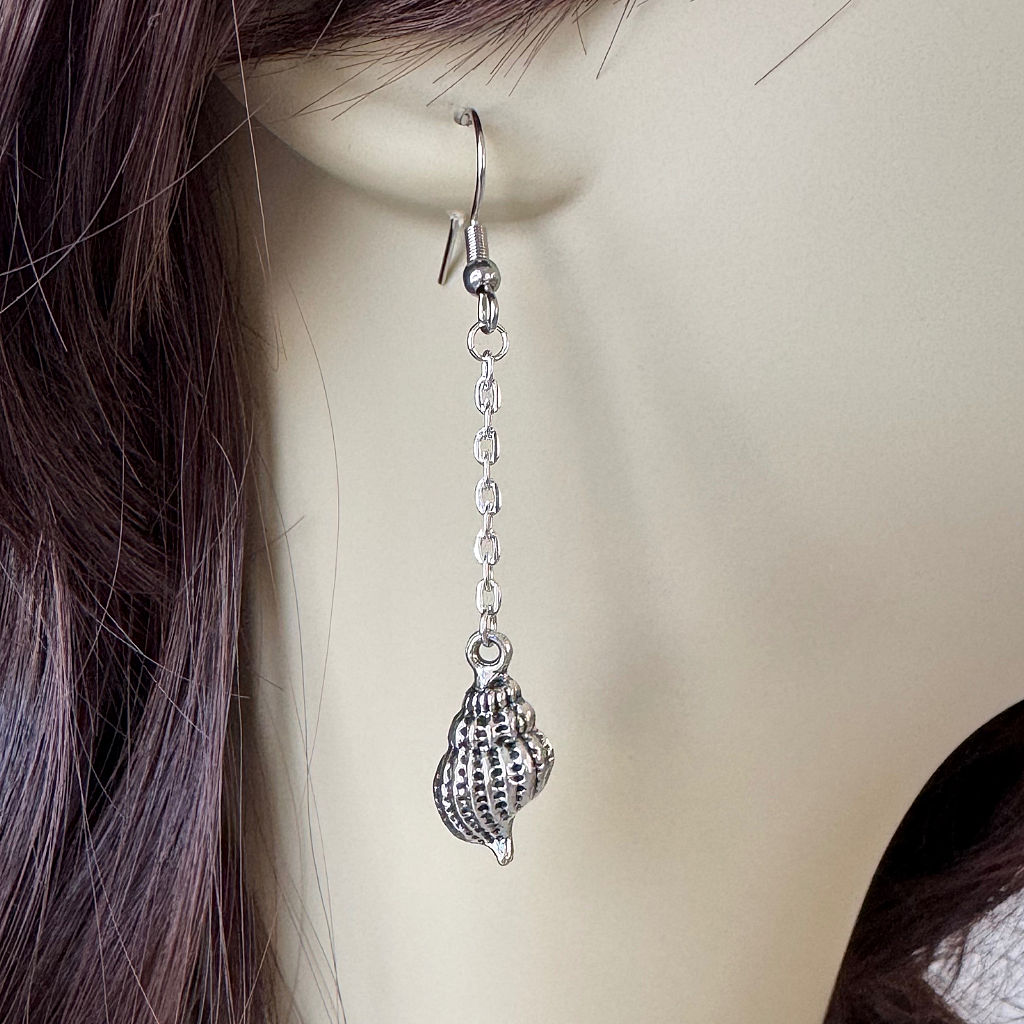 Silver Seashell Dangle Earring On A Woman.