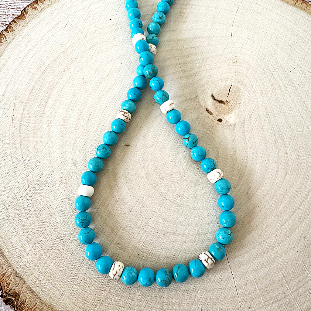 Turquoise Blue and White Magnesite Beaded Necklace on a wooden surface