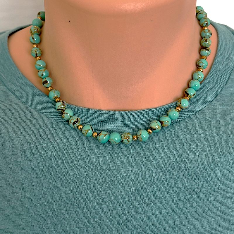 A sea green howlite and shell beaded necklace with gold stainless steel accents.