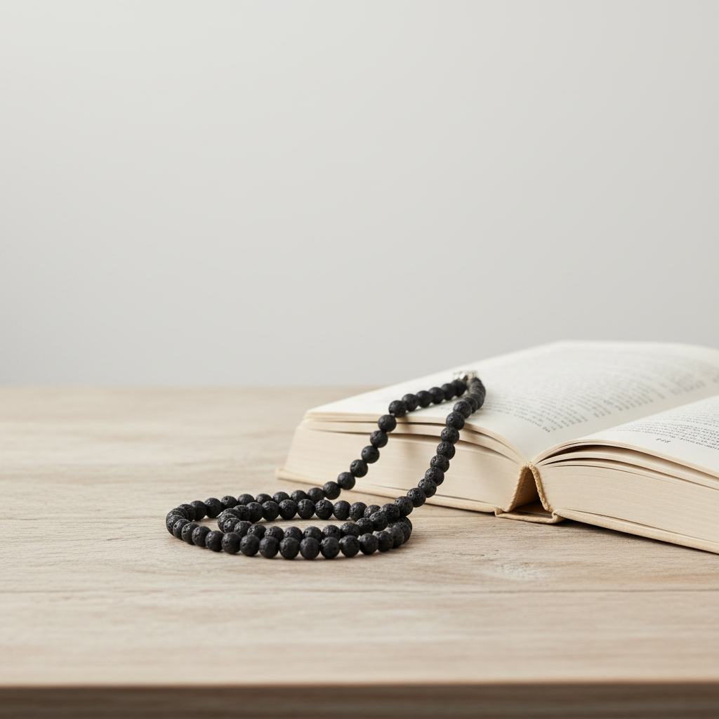 Mens Black Lava 10mm Necklace On A Table with Book