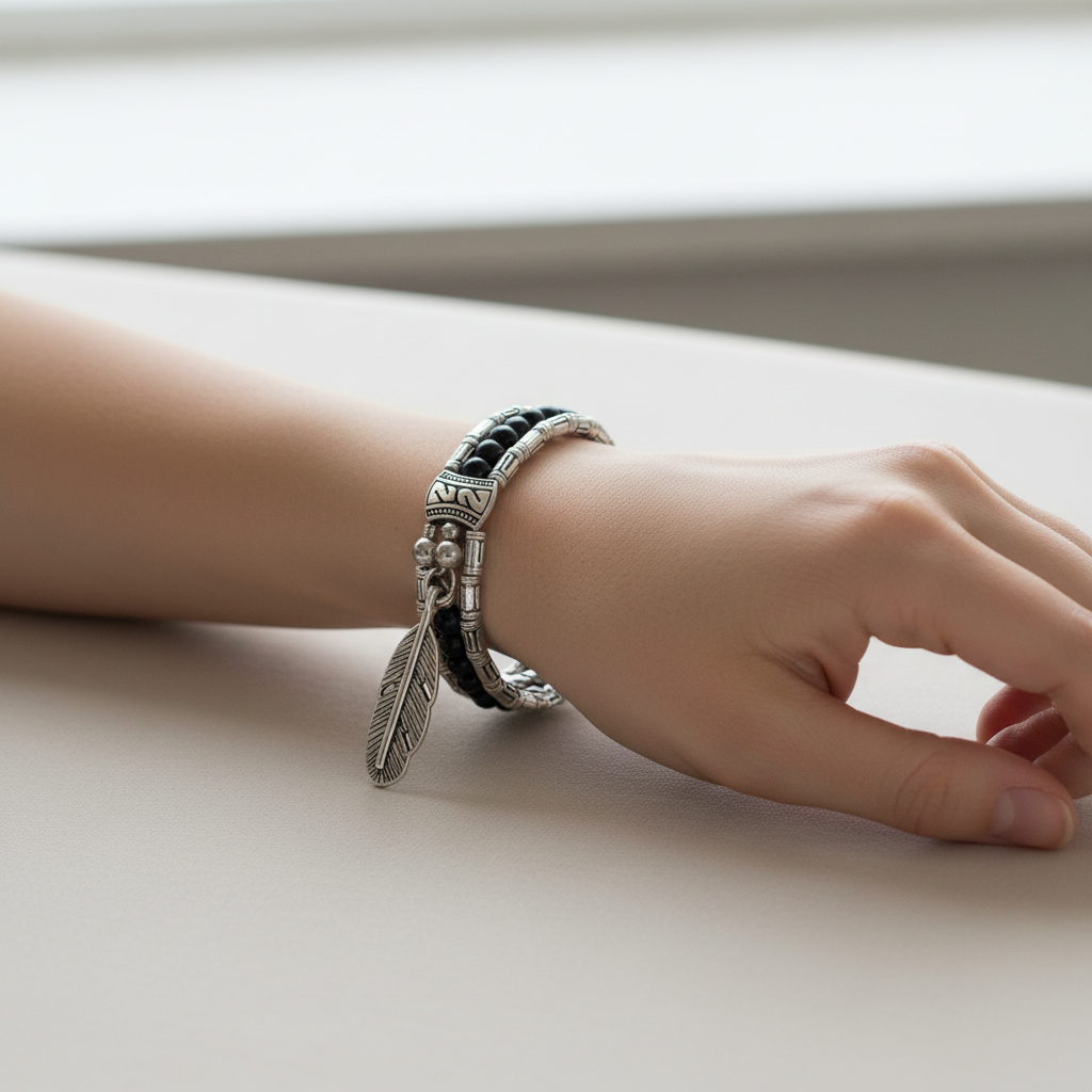 Silver Tibetan Feather and Black Beaded Bangle Bracelet On A womans Wrist.