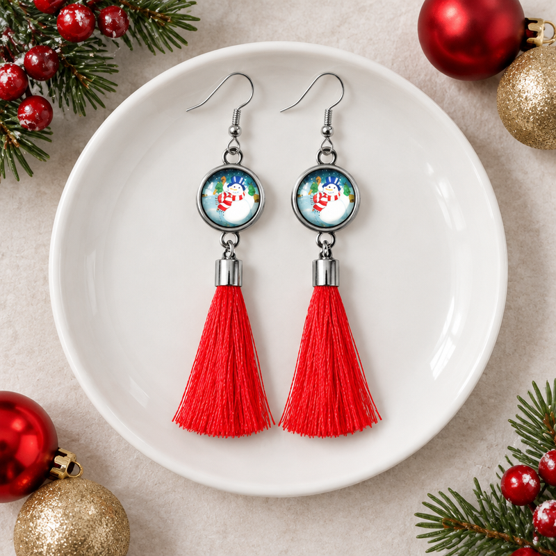 Christmas Snowman and Red Tassel Dangle Earrings On A Dish.