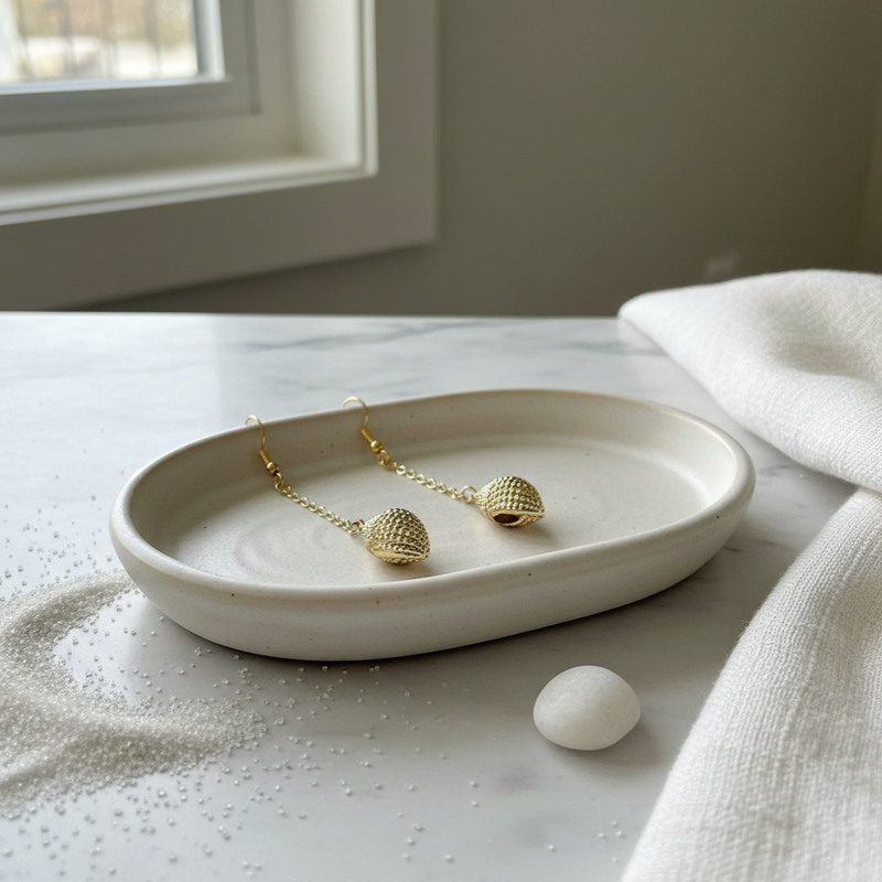 Gold Shell Earrings in s Dish.