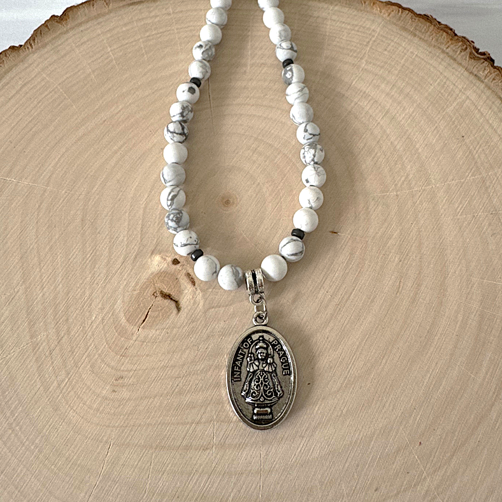 Mens 6mm White Howlite and Hematite Infant of Prague Beaded Necklace On A Display