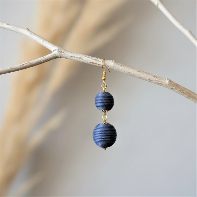 Navy Blue Thread Ball Dangle Earrings on a branch.