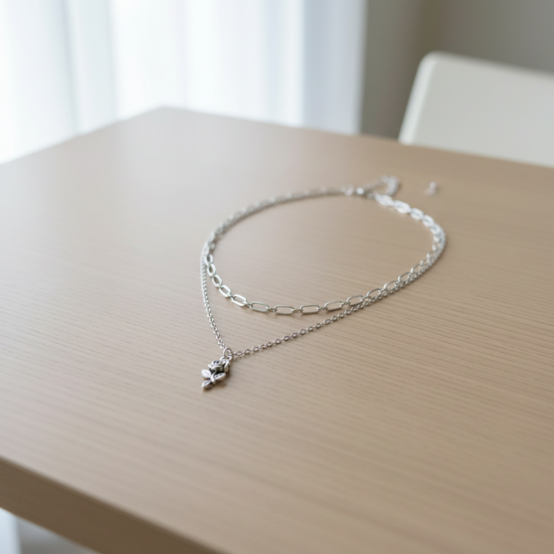 Silver Layered Rose Necklace On A Table.