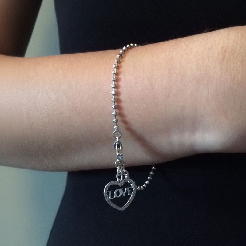 Sterling Silver Heart LOVE Charm Bracelet On A Womans Wrist.