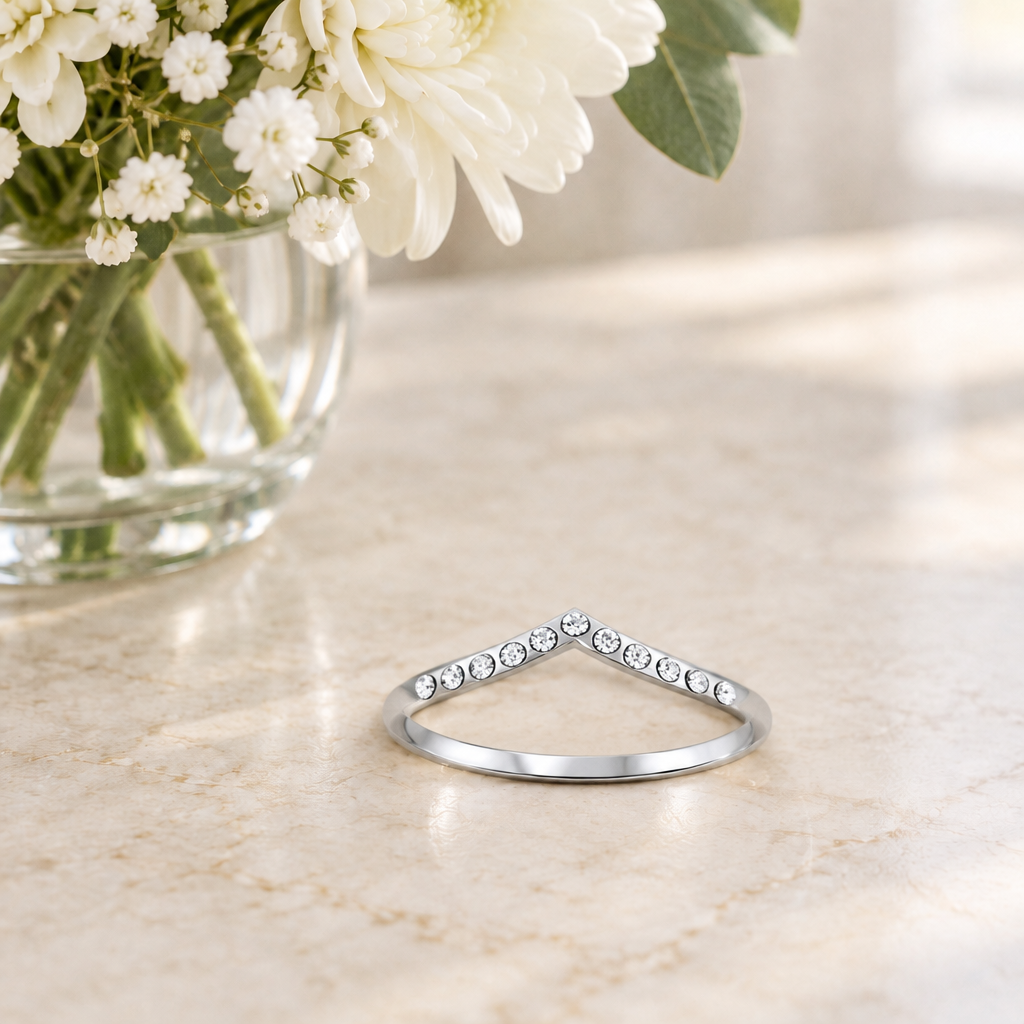 Sterling Silver CZ V Shaped Ring on a table beside a flower vase