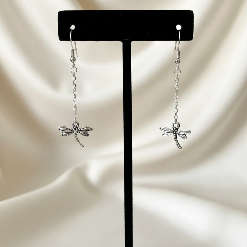 Silver Dragonfly Dangle Earrings On A Stand.