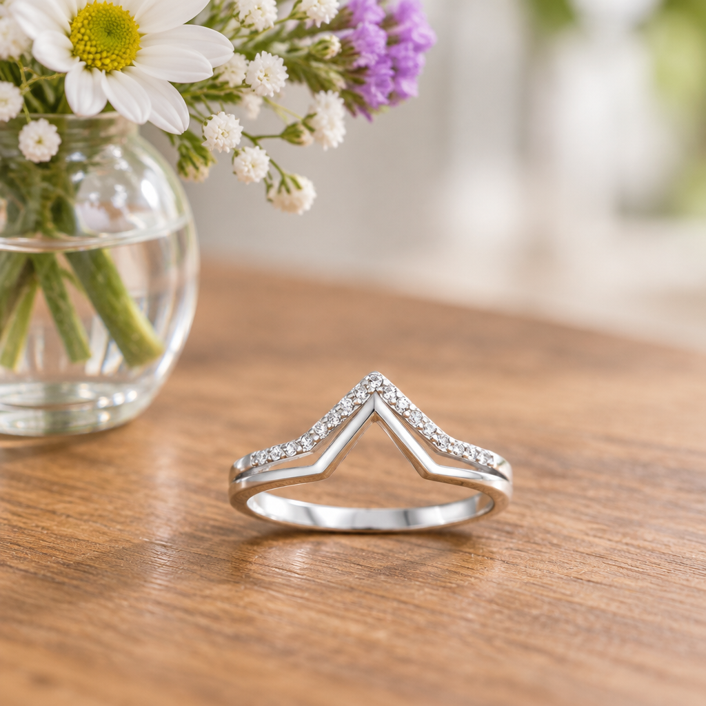 Sterling Silver Double V CZ Ring laid on a table next to a flower vase