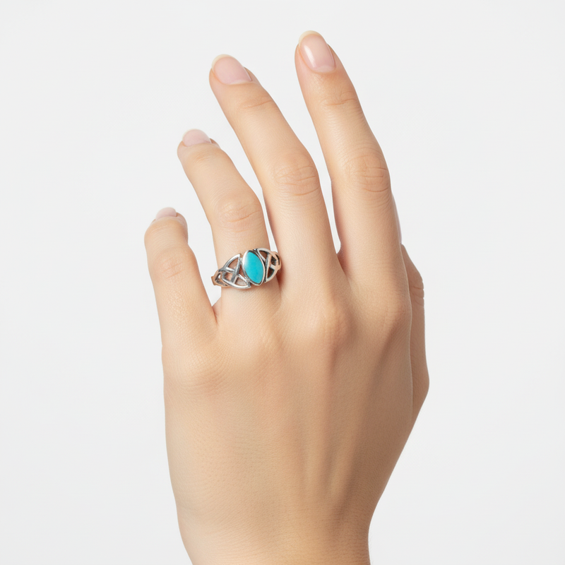 Turquoise Celtic ring on a womans hand.