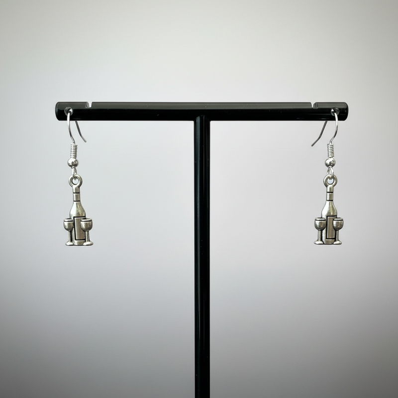 Wine bottle and glass earrings on black stand.