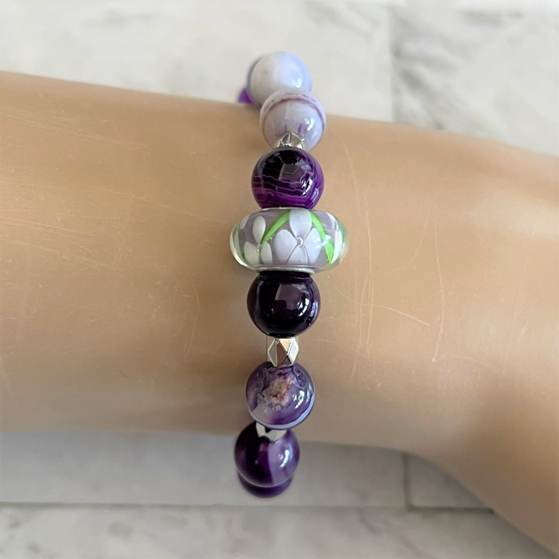 Womens Beaded bracelet with a variety of purple agate and silver hexagon beads, featuring a large flower-shaped bead in the center.